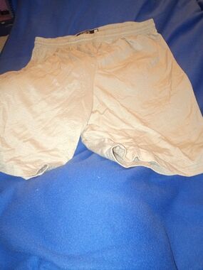Lightweight beige athletic shorts designed for training and everyday wear.